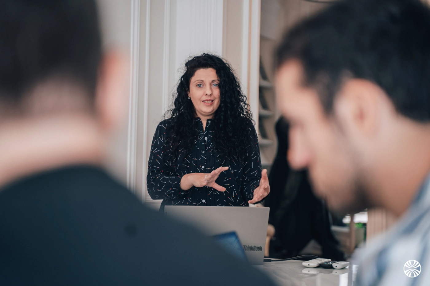 Femme présentant devant des collègues attentifs.
