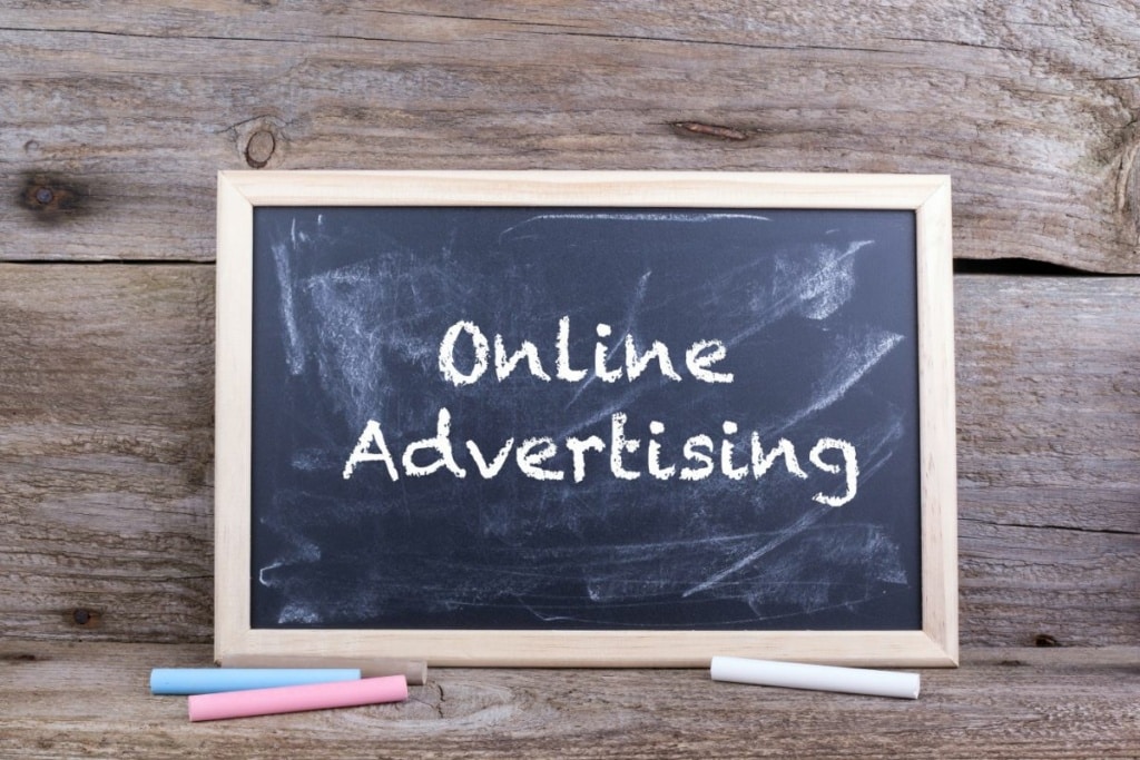 Mots "online advertising" écrits à la craie sur un tableau.