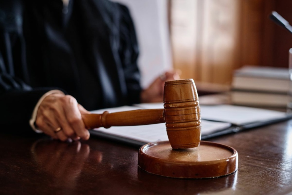 Une main de juge tient le marteau de justice.