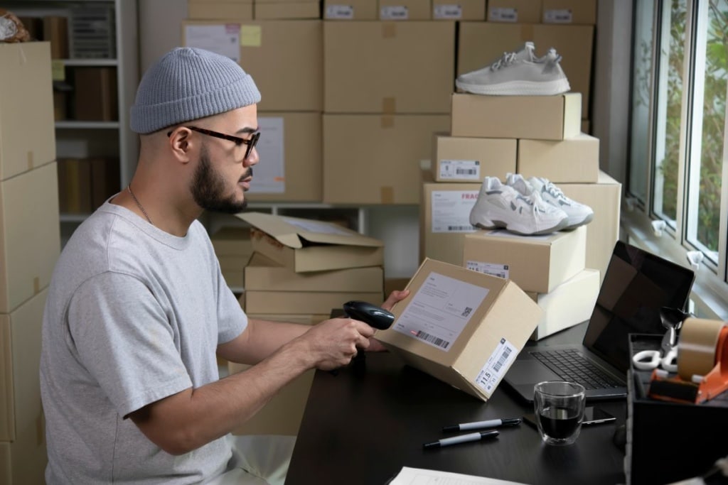 Un e-commerçant scanne des boîtes de chaussures.
