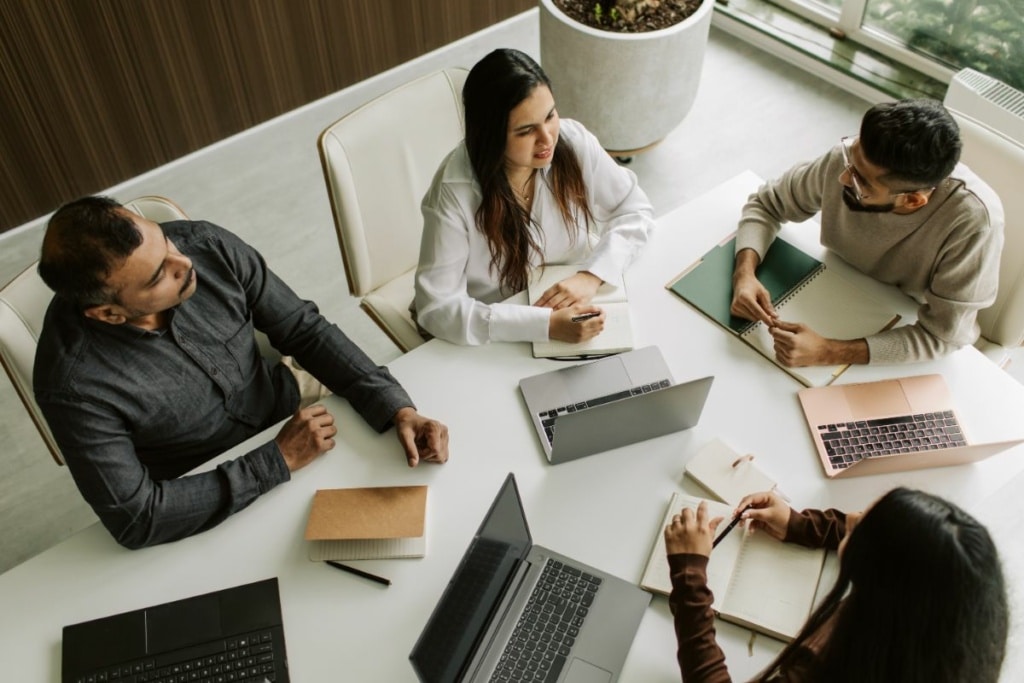 Quatre personnes travaillent autour d'un bureau.