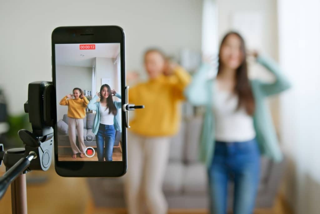 Deux femmes enregistrent une vidéo sur un téléphone.