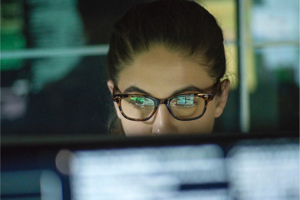 Femme qui observe un écran avec attention.