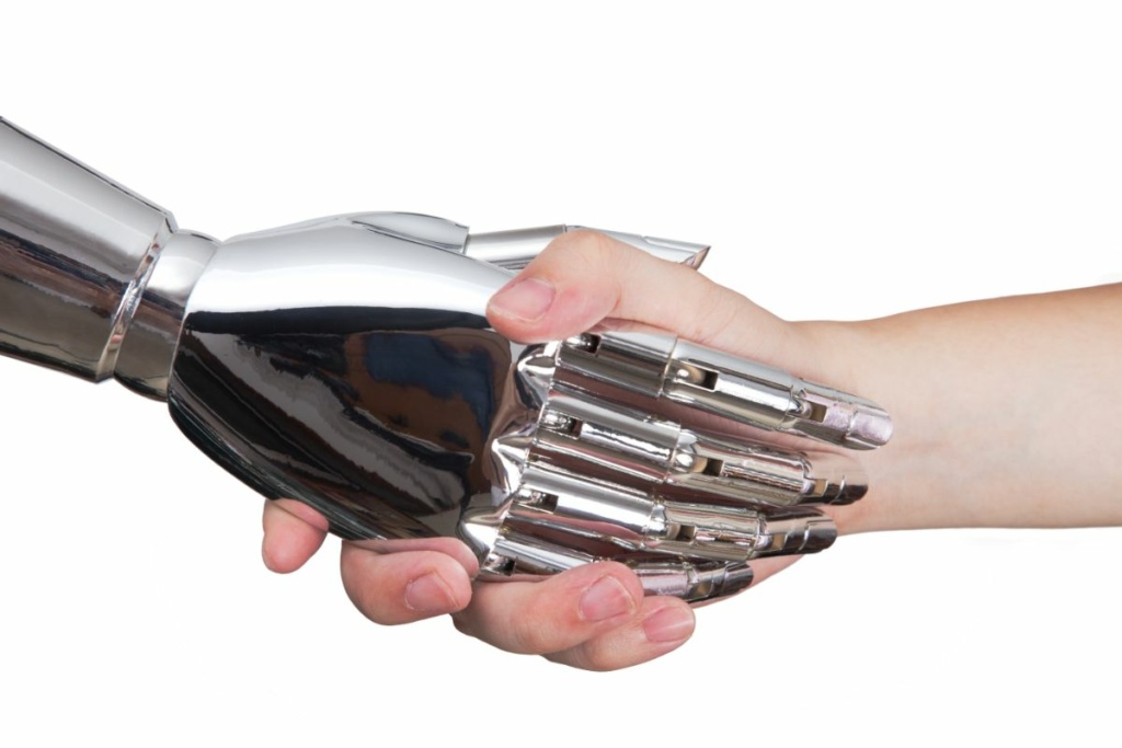 Une main robotique serre une main humaine.