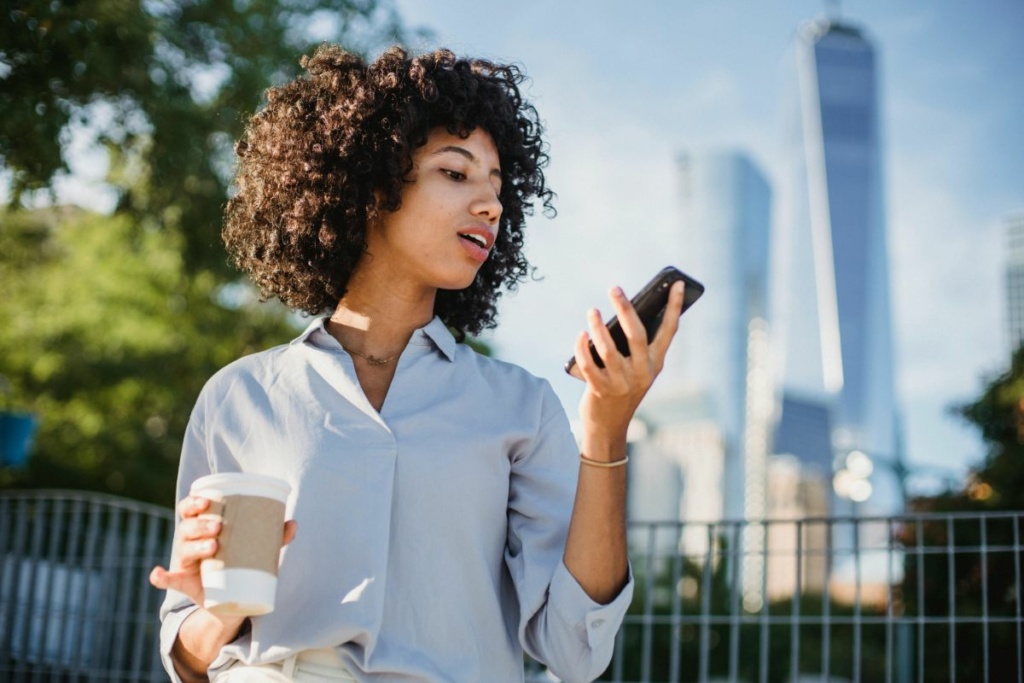 Une femme regarde son téléphone dans la rue.